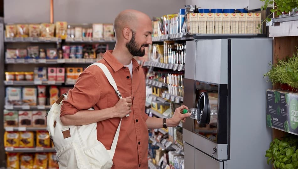 Photo d’un homme rapportant des cannettes dans un automate de déconsigne