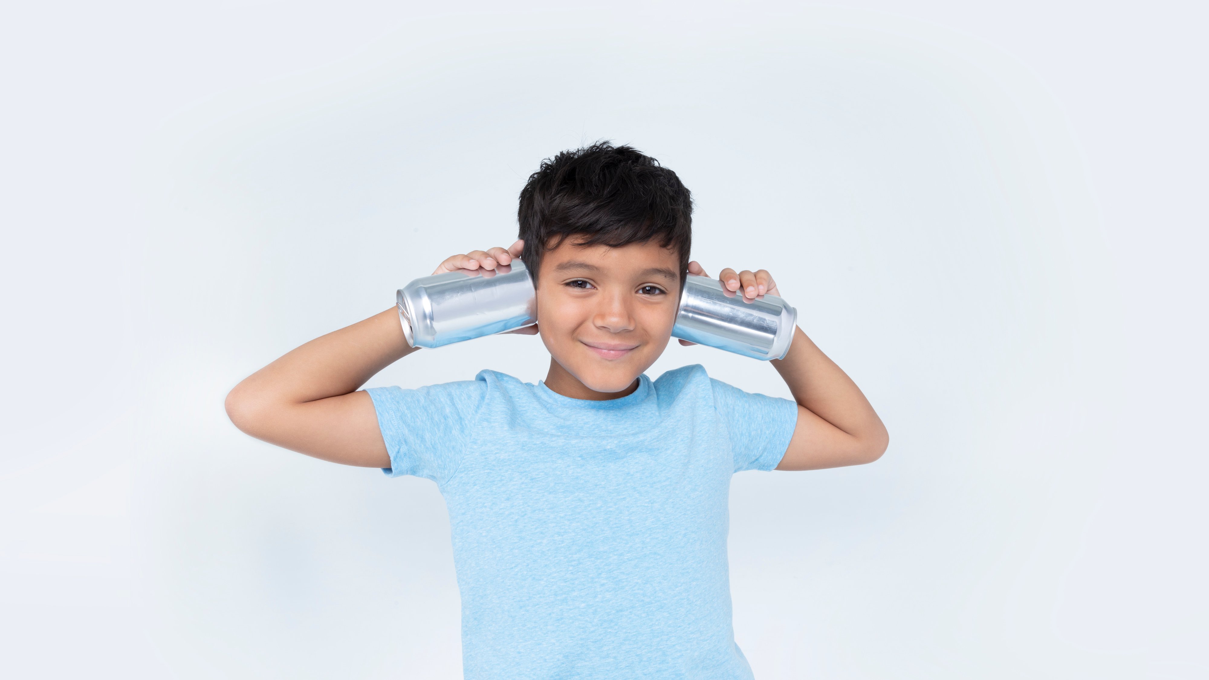 Boy holding cans up to his ears