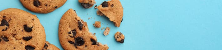 Vier chocolate chip cookies, waarvan er één in stukken is gebroken