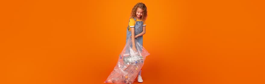 Porträt eines Mädchens mit einer Tasche voller Verpackungen vor einem orangefarbenen Hintergrund hält